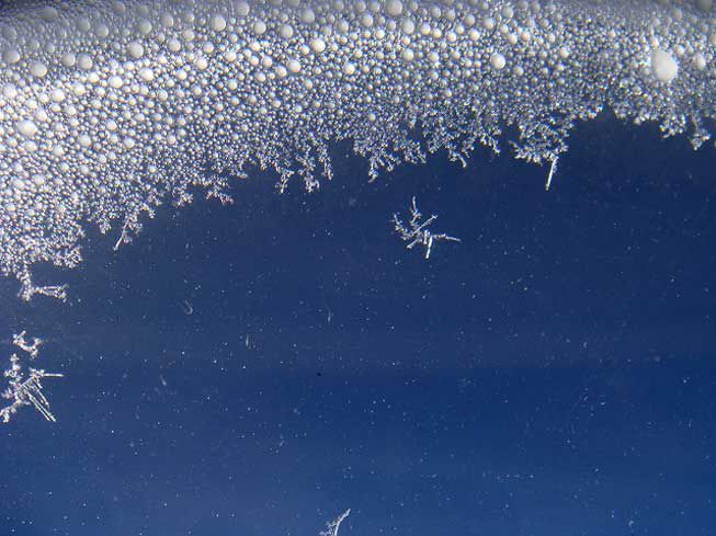 Copos de nieve fotografiados a lo largo de la curva de la ventanilla de un avión