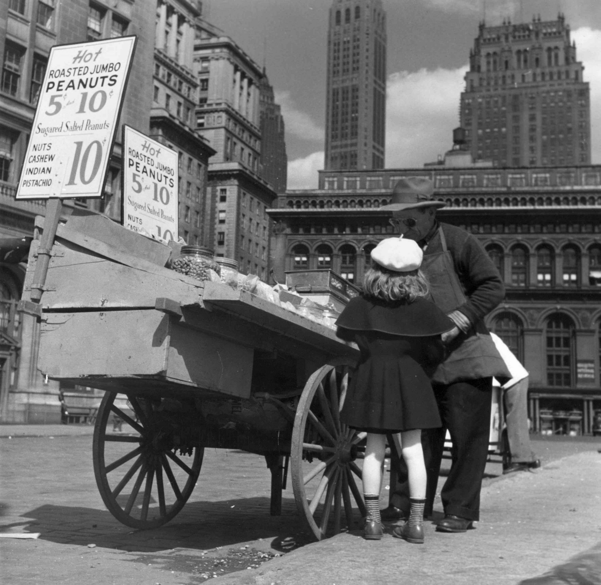 Una chica compra frutos secos a un vendedor de cacahuetes en Nueva York en 1949