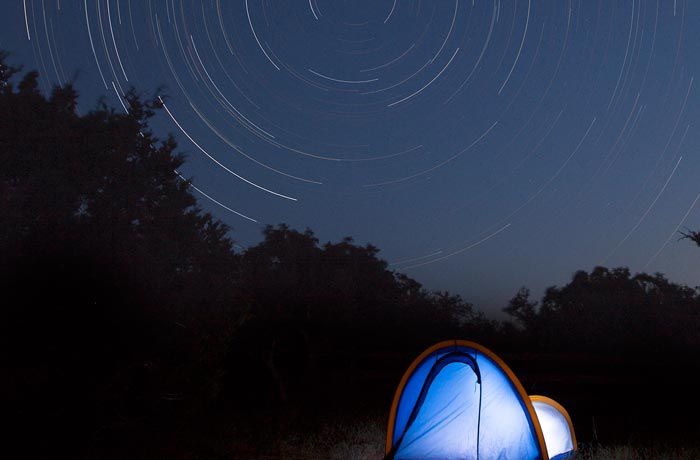 Un campista duerme bajo el cielo nocturno en Dripping Springs, Texas.
