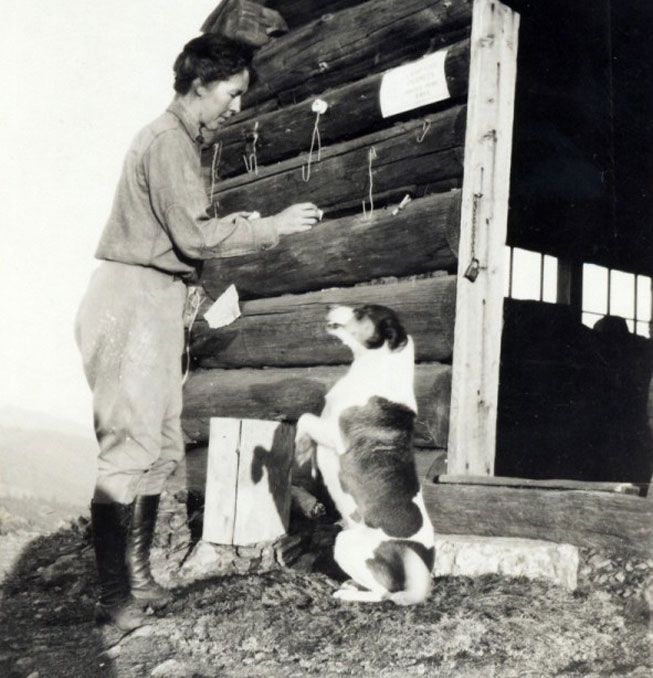 Hallie Daggett, primera mujer oficial de campo del Servicio Forestal, juega con su perro en la estación de Eddy Gulch en el Pico Klamath