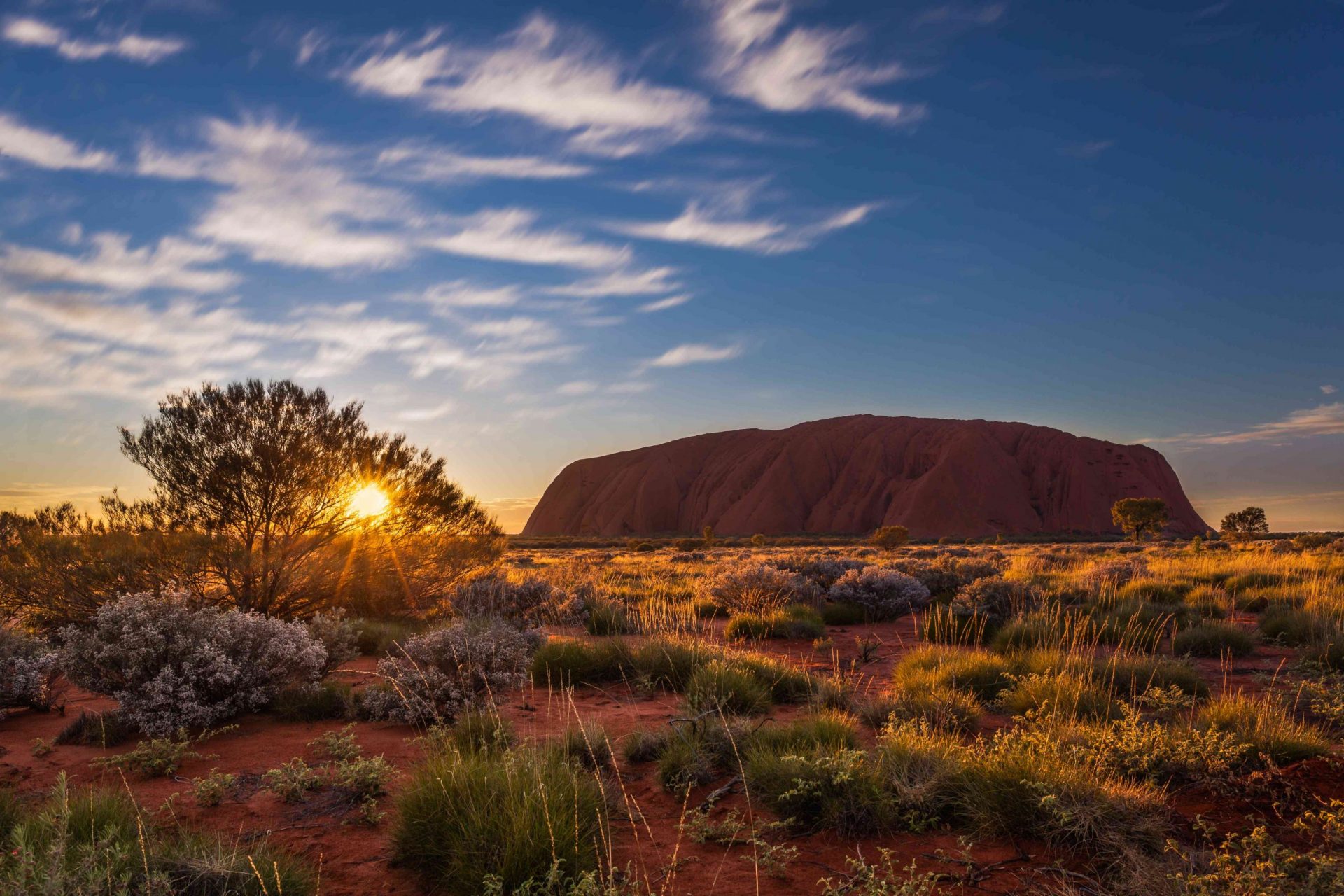 Sol saliendo sobre Uluru, también conocido como Ayers Rock, una gran formación rocosa de arenisca situada en el sur del Territorio del Norte, en el centro de Australia