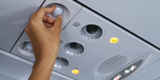 Una mano ajusta el respiradero de un asiento de avión