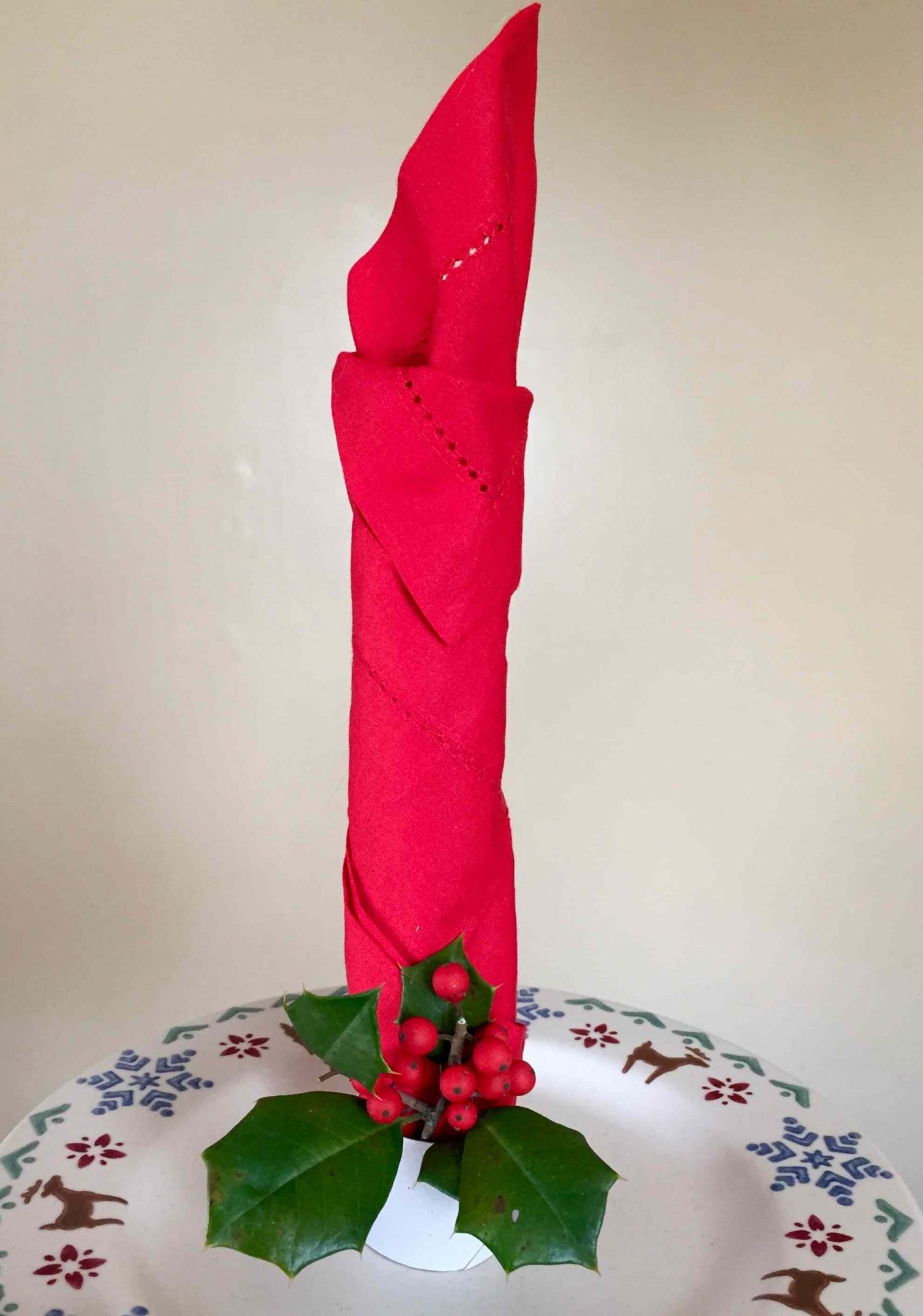 servilleta roja doblada en forma de vela