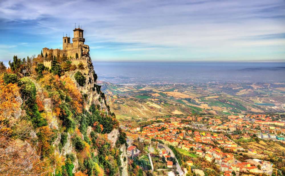 Un castillo situado en lo alto de un acantilado con vistas a un vasto valle en San Marino