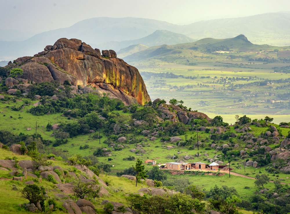 Una gran formación rocosa se eleva sobre un exuberante valle verde en Eswatini