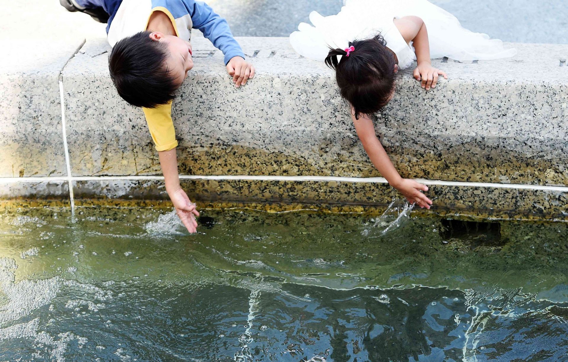 Niños jugando en una fuente de agua
