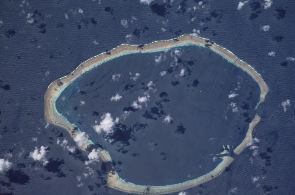 Una foto aérea de un atolón circular en el Océano Pacífico
