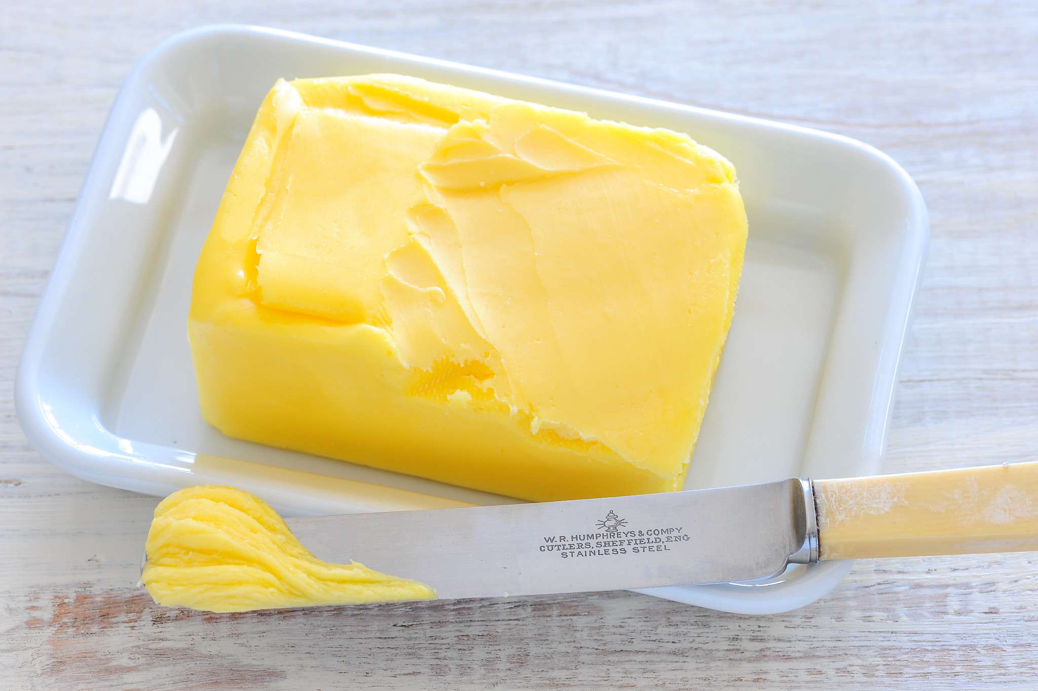 trozo de mantequilla amarilla con cuchillo de mantequilla