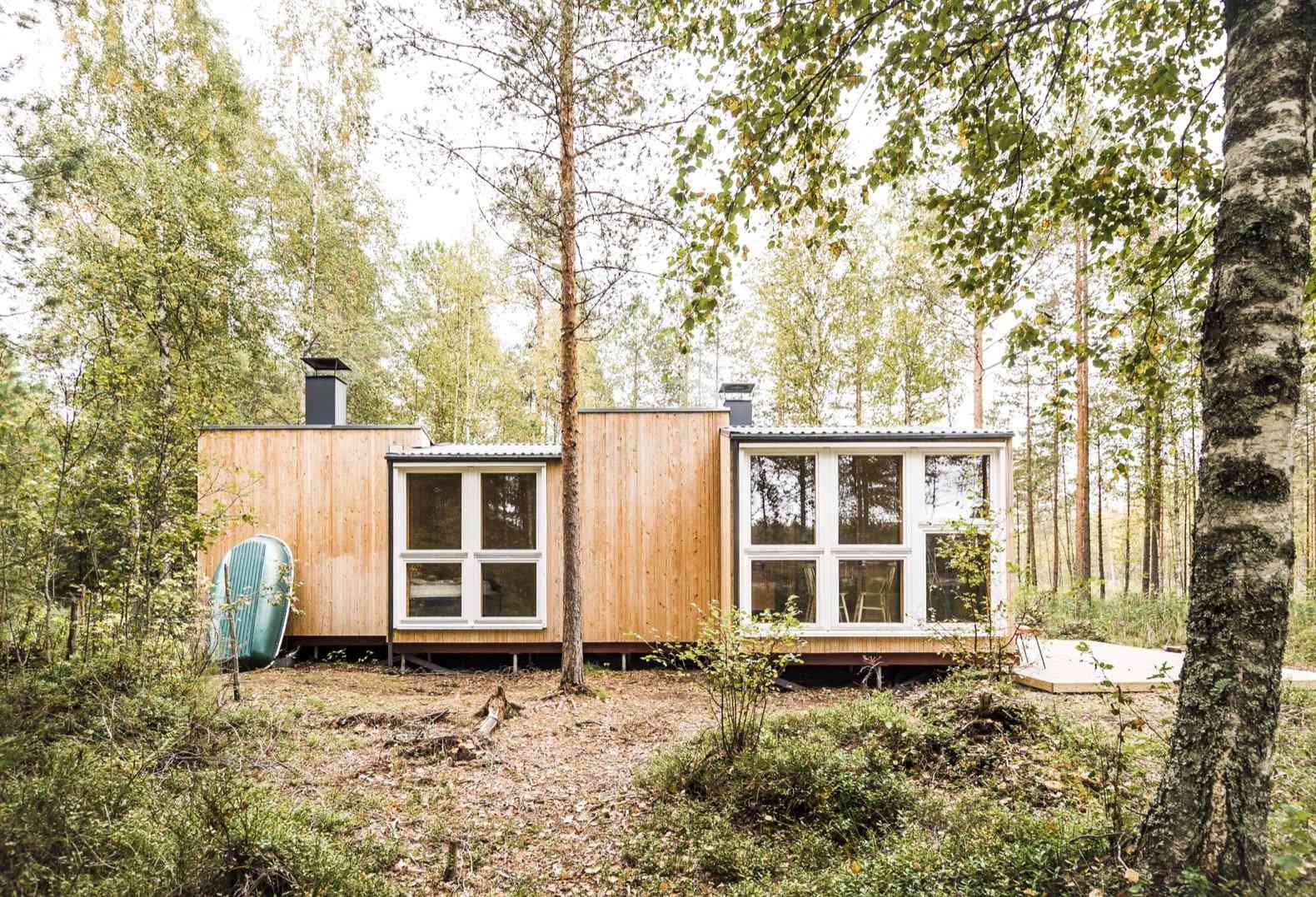 Casa diminuta con grandes ventanas en un bosque