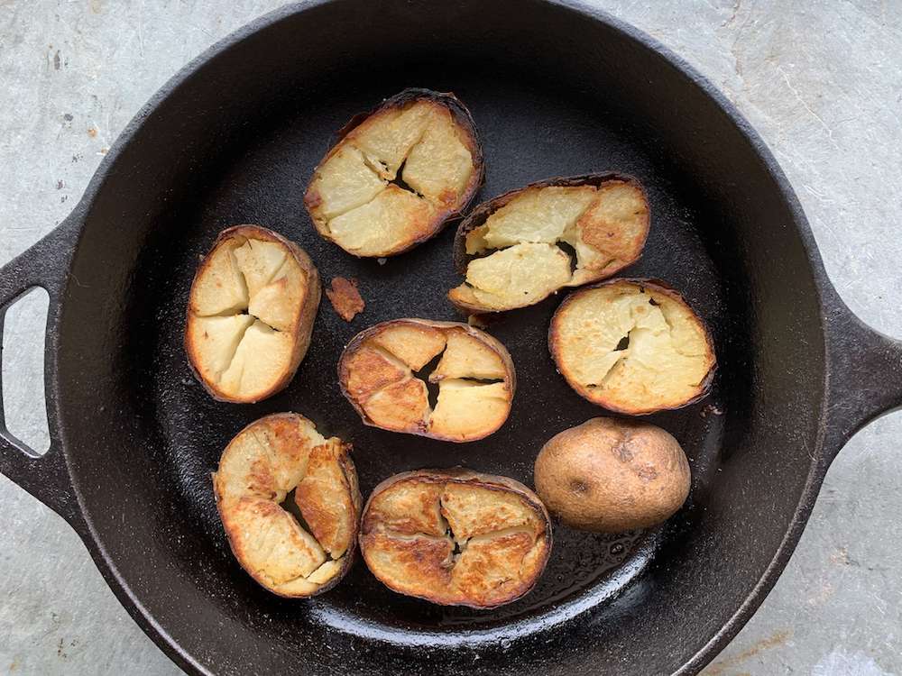 freír patatas viejas en rodajas en una sartén de hierro fundido