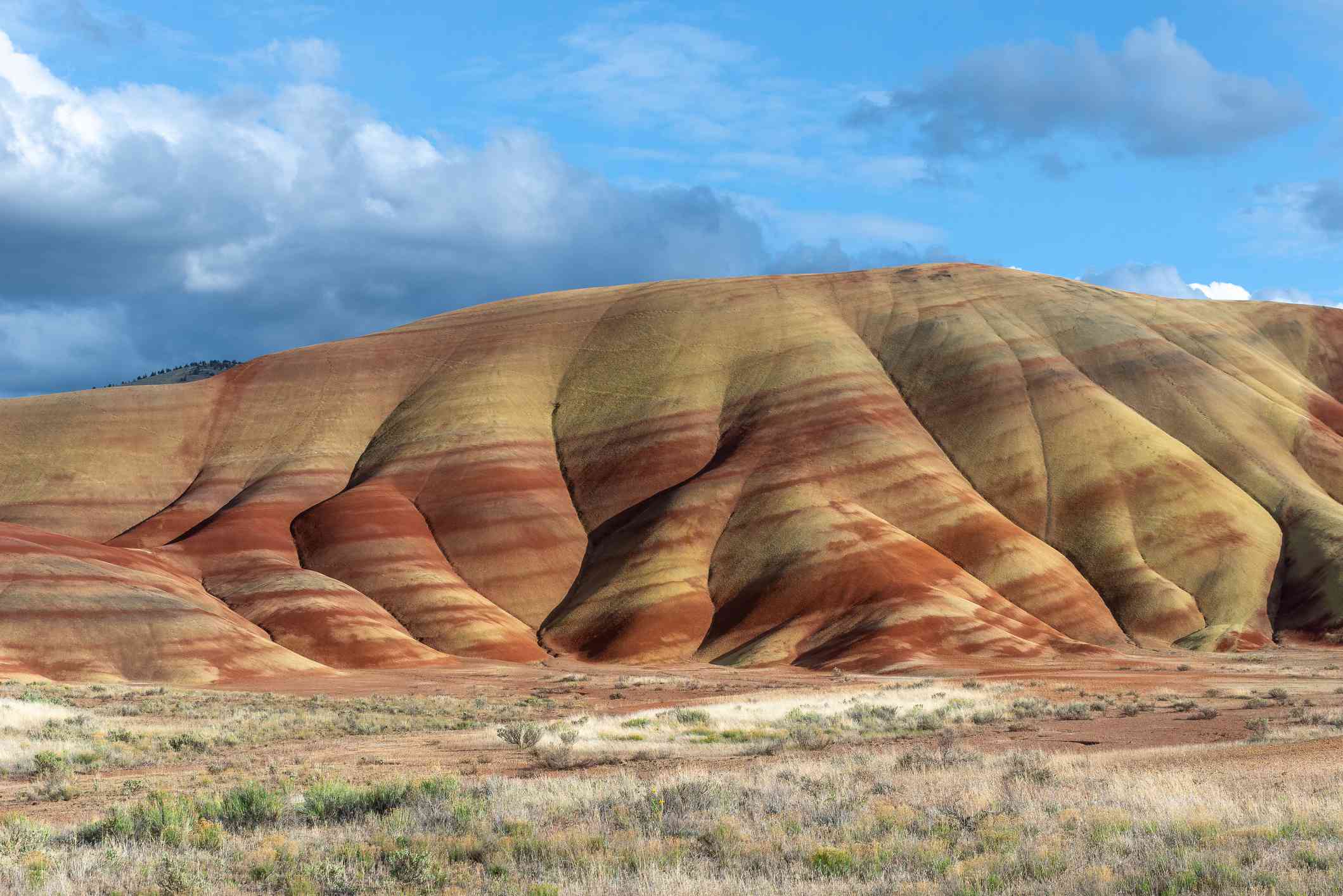 Una colina en el alto desierto de Oregón con estrías amarillas y rojas