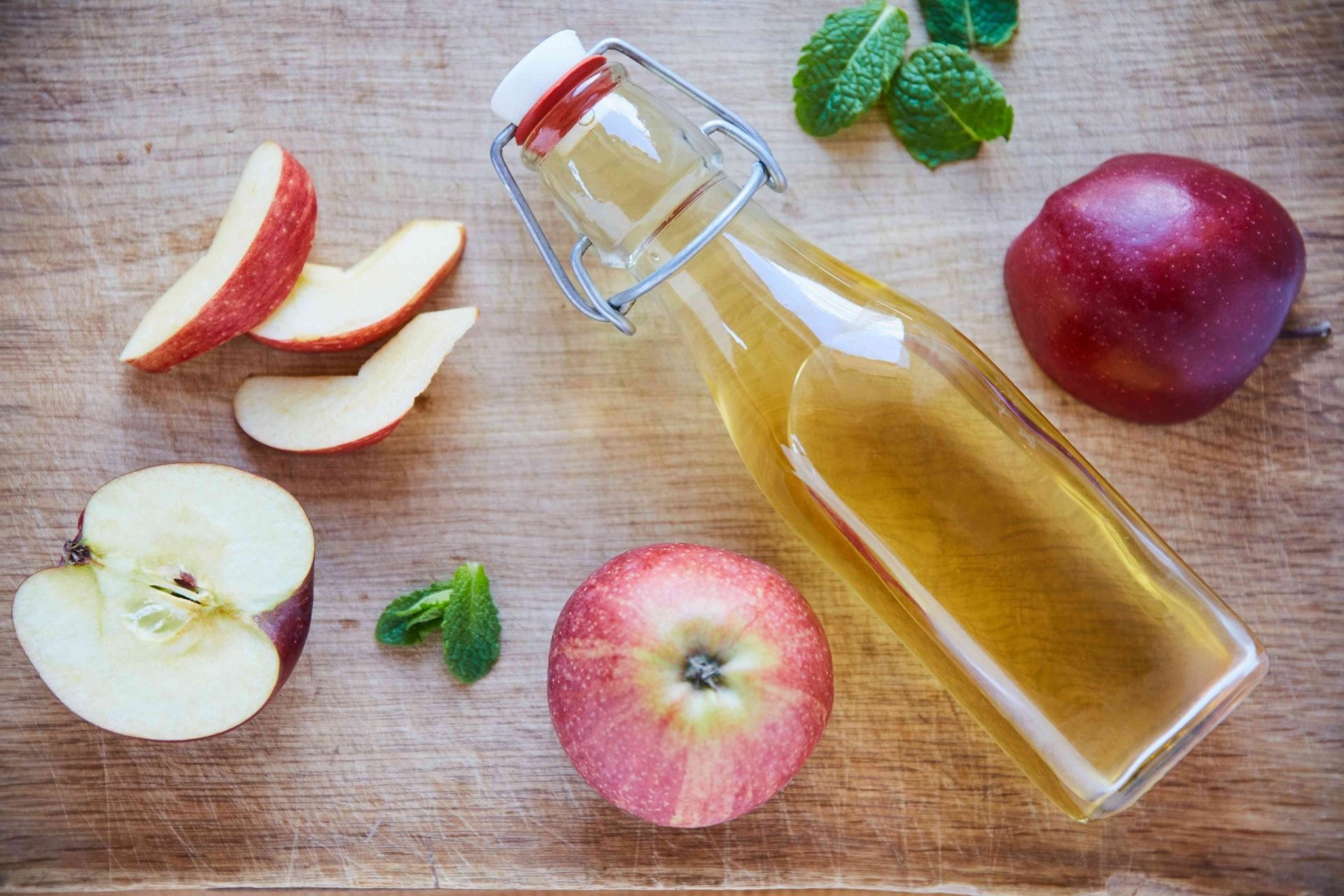 Toma aérea de una botella de vinagre de sidra de manzana sobre una mesa de madera