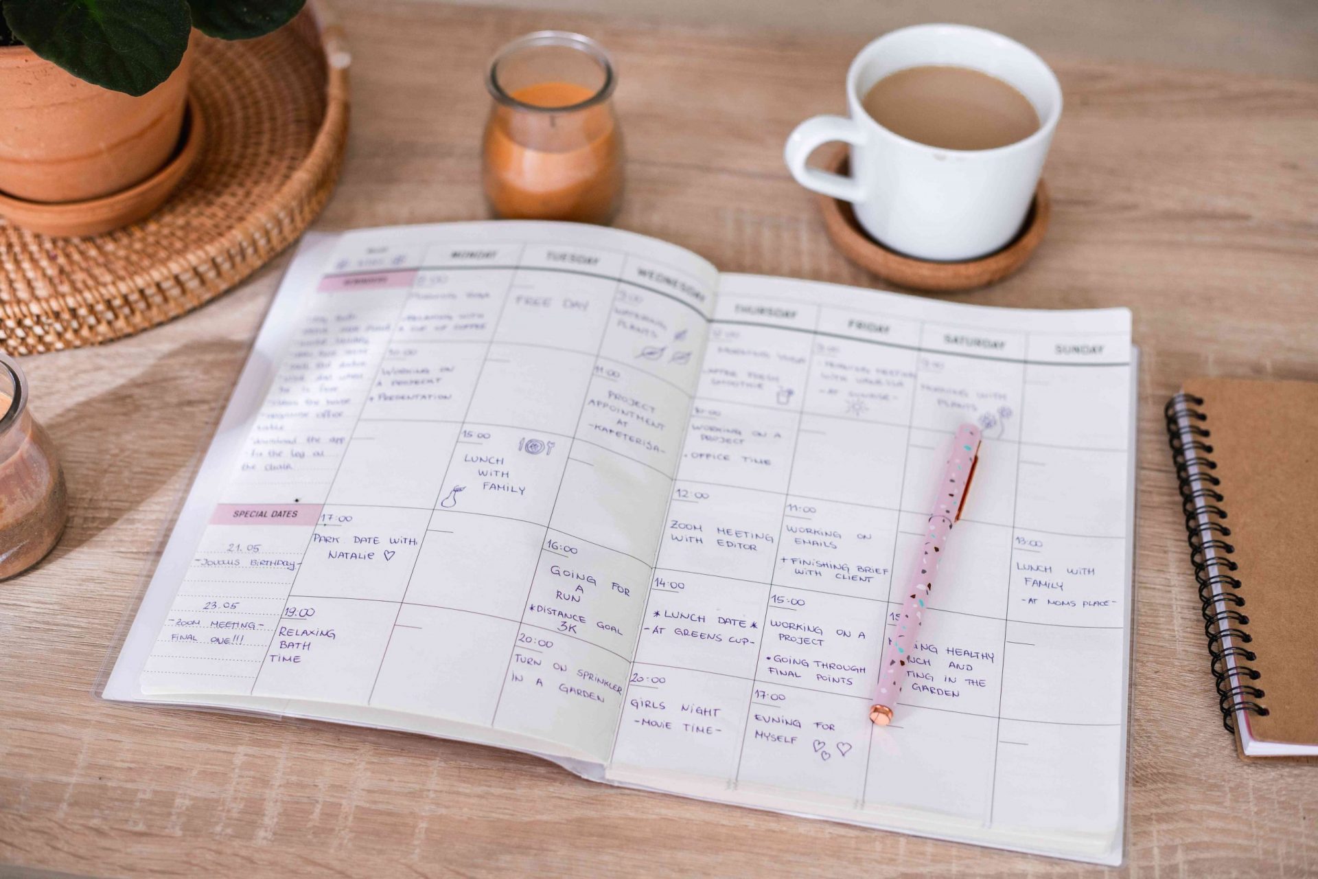imagen de una agenda llena de actividades en un escritorio de madera junto a una taza de café