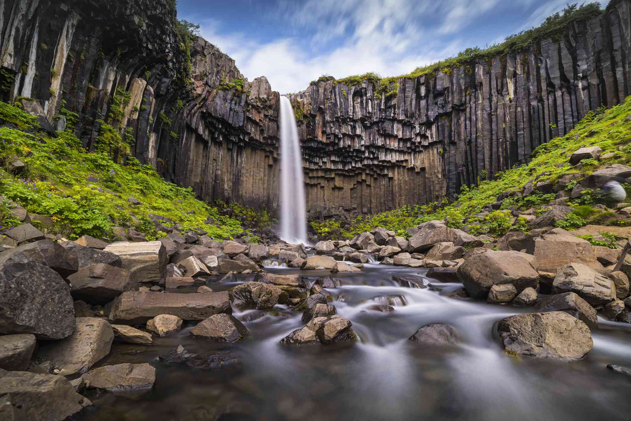 Gran cascada flanqueada por roca volcánica articulada en forma de columna