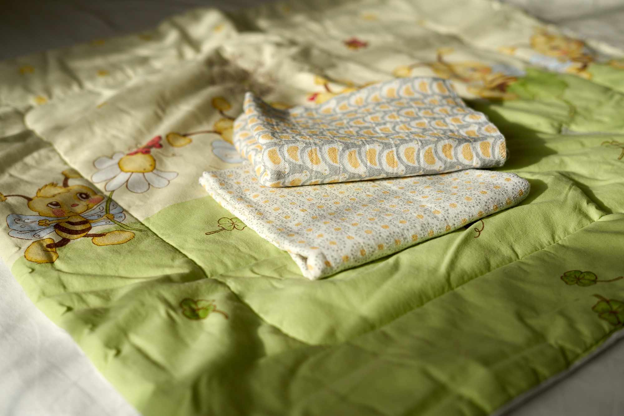 pañales de tela reutilizables en una manta para bebés con abejas de dibujos animados