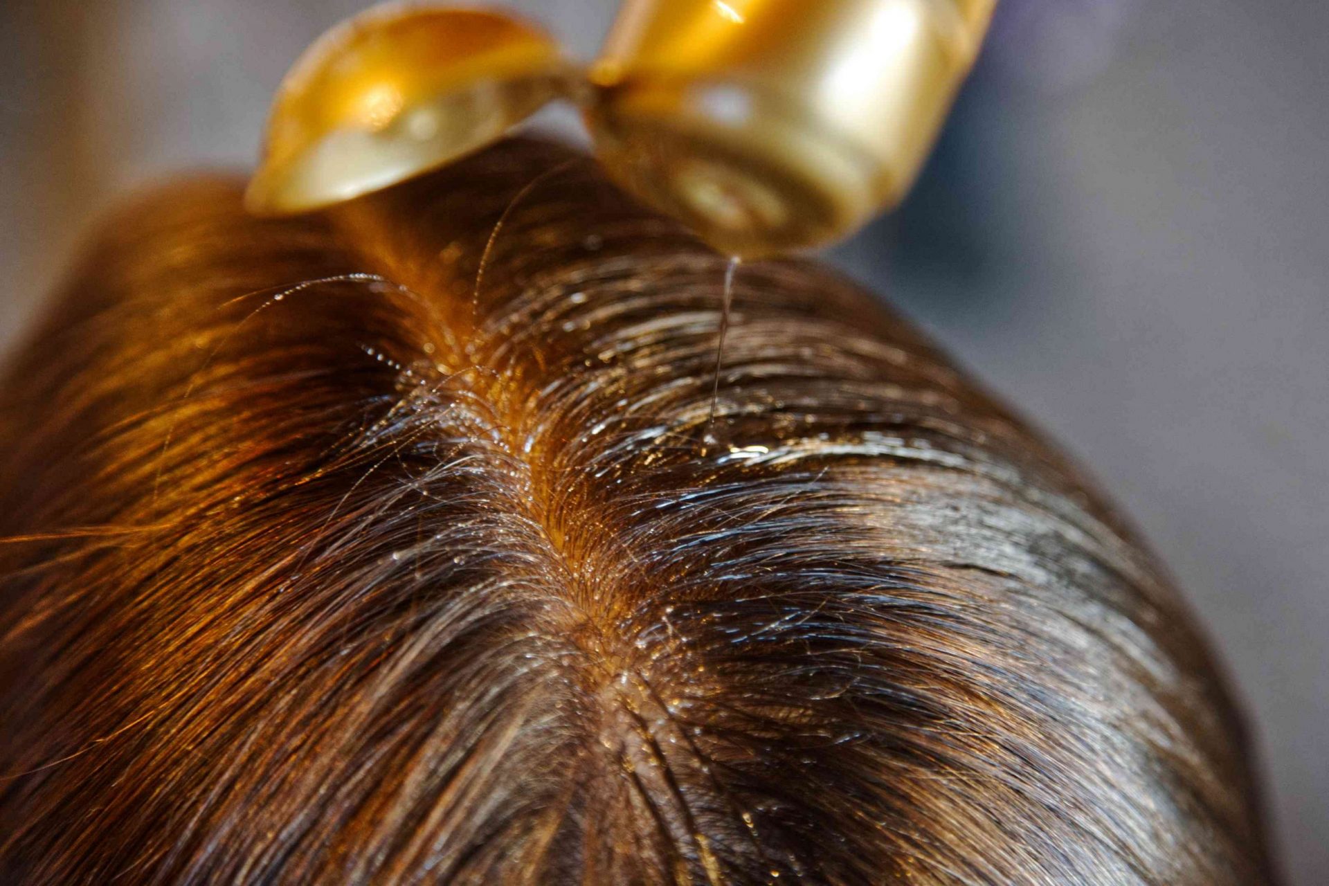 primer plano del cabello dividido con aceite exprimido en las raíces