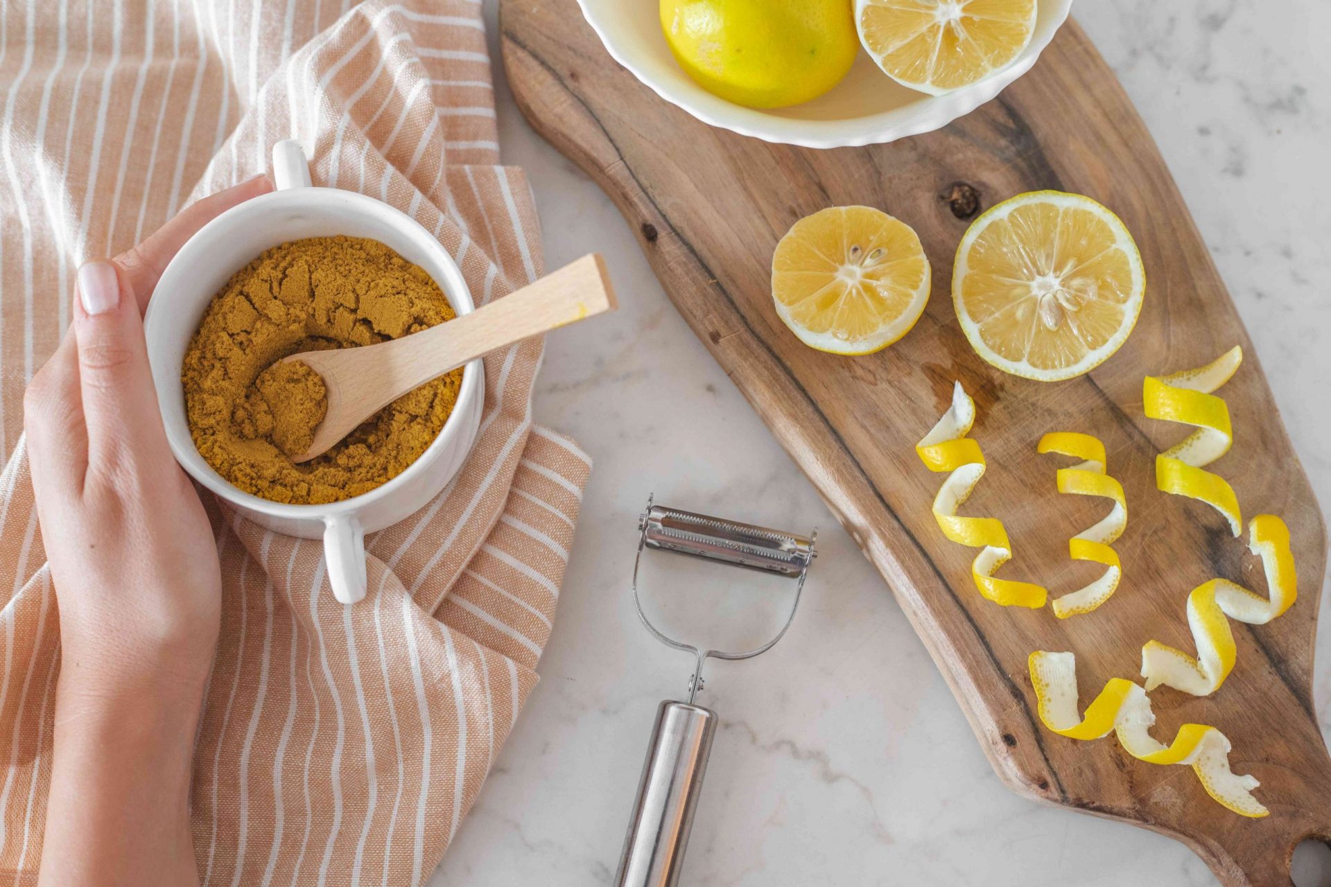 El azúcar moreno y las cáscaras de limón se extienden sobre una tabla de cortar de madera para hacer azúcar de cítricos