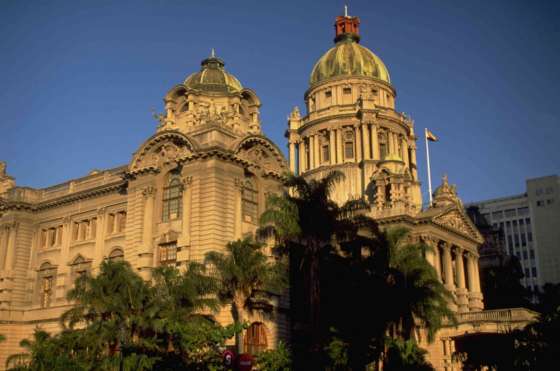 ayuntamiento de Durban, Sudáfrica, con columnas y una alta cúpula, iluminada por el sol poniente