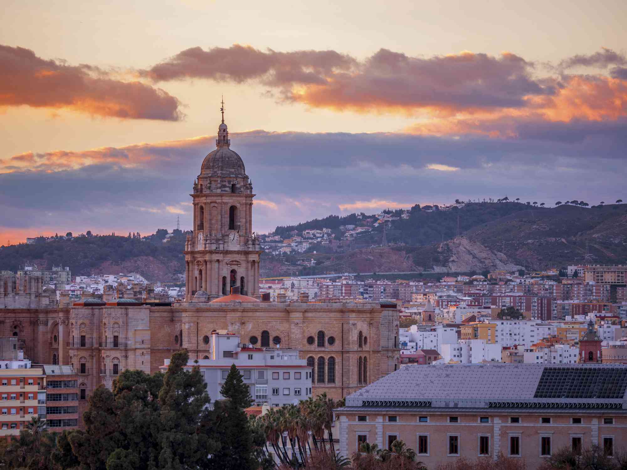 la cúpula de la catedral de Málaga se eleva sobre la ciudad en España mientras el sol comienza a ponerse