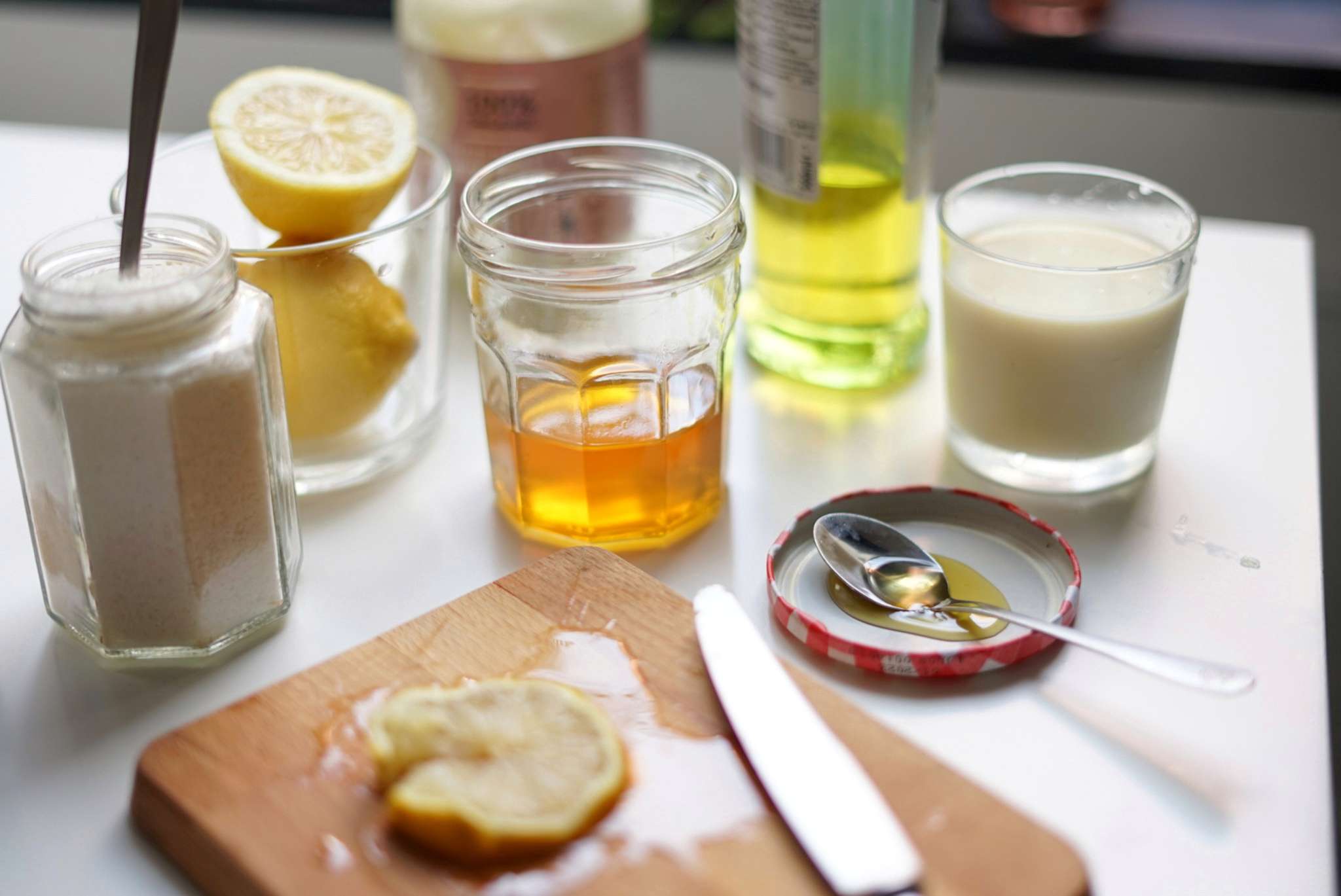 miel, limones cortados, leche y almendras molidas sobre la mesa para un tratamiento de belleza natural