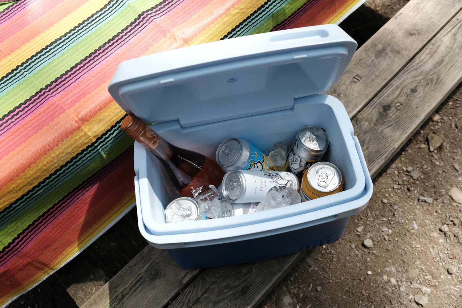 nevera abierta en la mesa de picnic llena de vino y cerveza y hielo