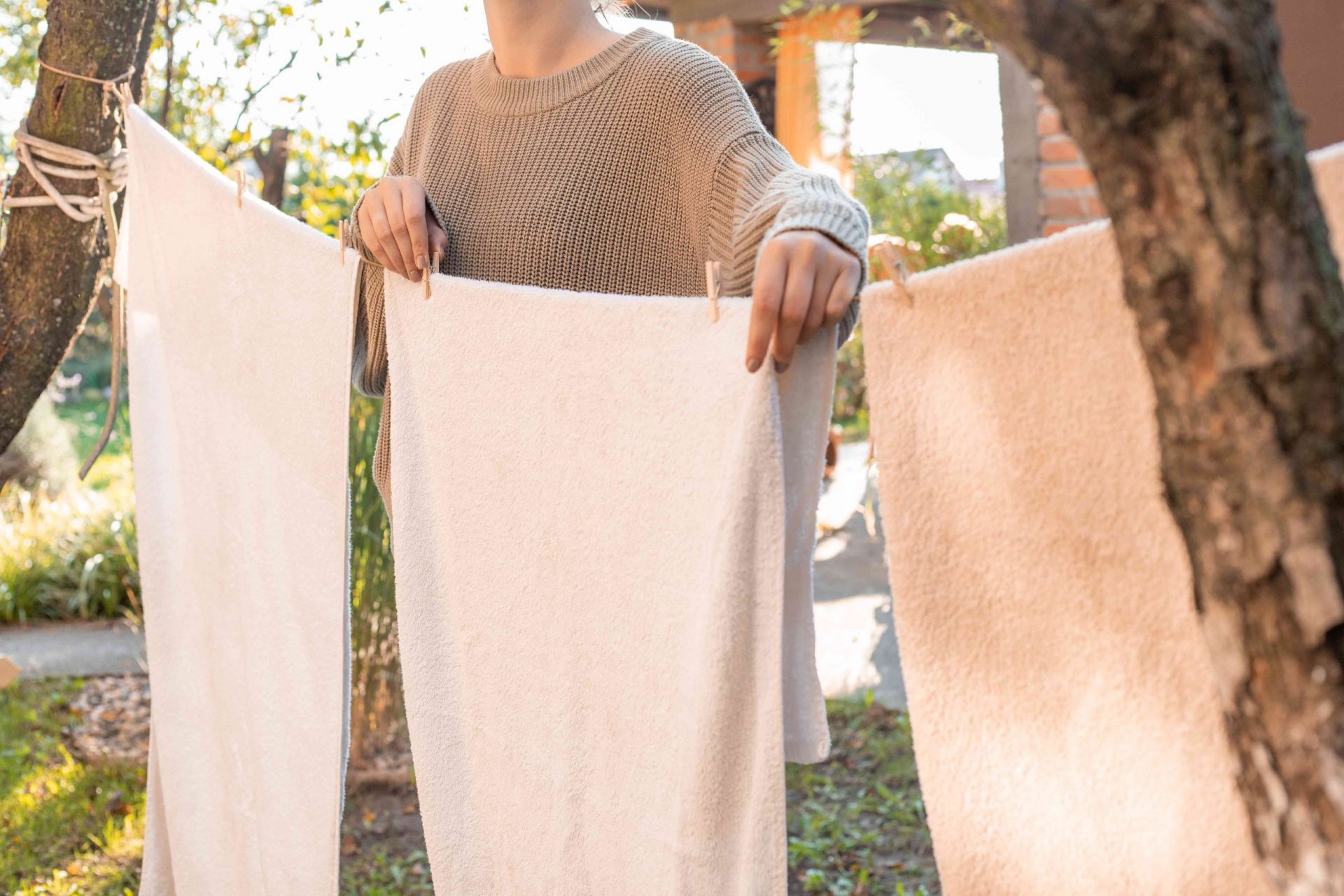 mujer cuelga las toallas fuera en la cola